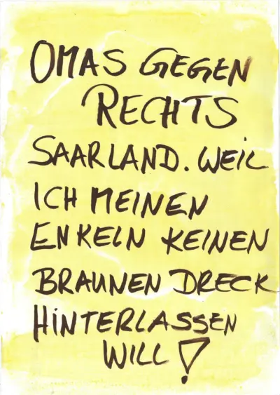 Ein Plakat mit händischer Aufschrift "Omas gegen rechts Saarland. Weil ich meinen Enkeln keinen braunen Dreck hinterlassen will!"