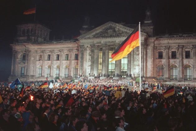 Vorplatz vor dem Bundestag bei Nacht mit Menschenmassen, die Deutschland- und EU-Fahnen schwenken