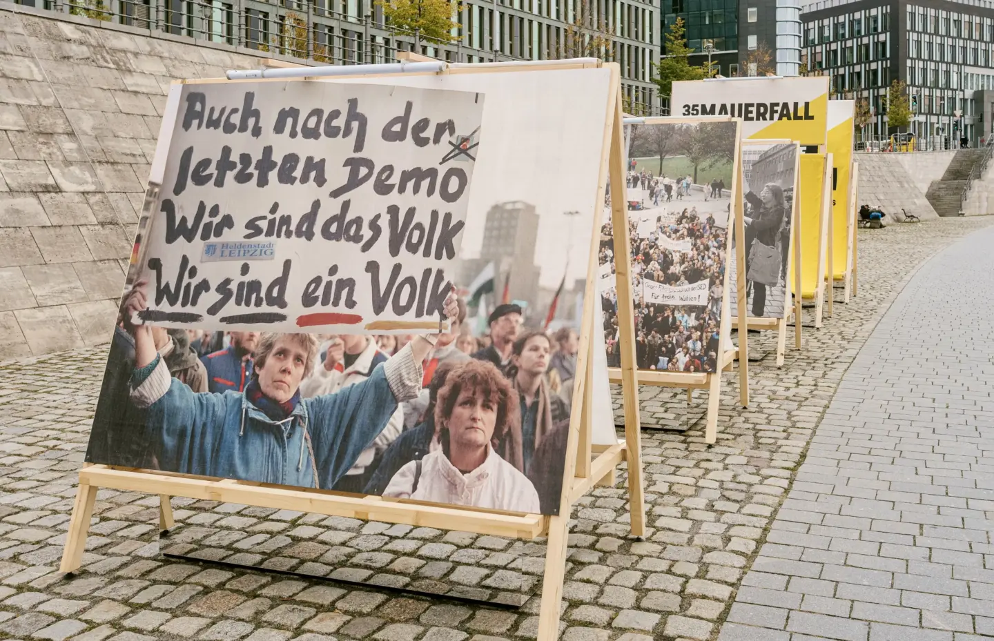 Ausstellung auf Holztafeln zeigt historische Fotos auf Ufergehweg